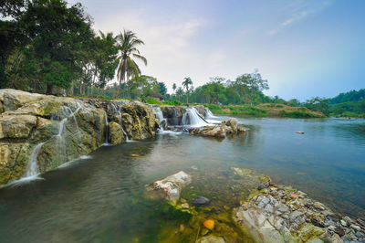 Scenic view of waterfall against sky