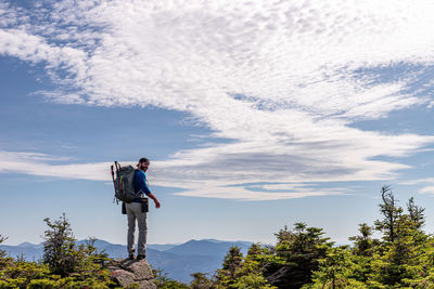 Man standing by tree against sky