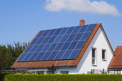 House with tiled roof covered with solar panels