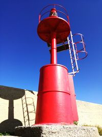 Low angle view of water tower against clear blue sky