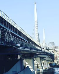 Low angle view of bridge and buildings against sky