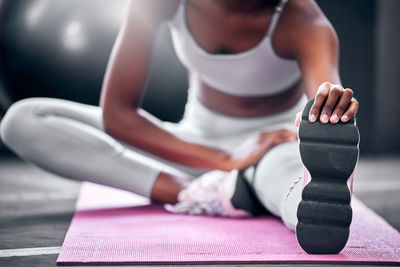 Low section of woman doing yoga at table