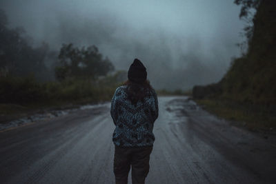 Rear view of man standing on road