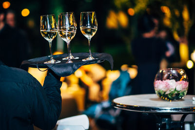Rear view of waiter carrying champagne at restaurant
