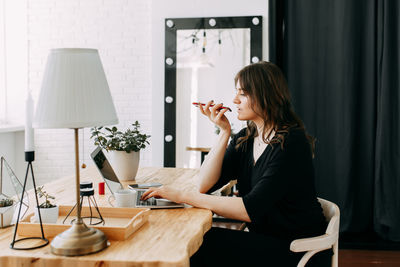 Business girl freelancer in casual clothes works using wireless technology in the home office