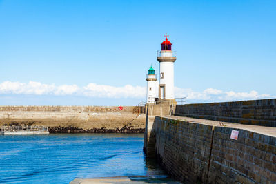 Lighthouse by sea against sky