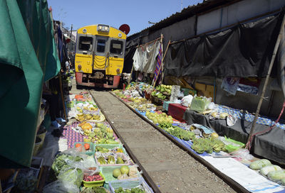 Train and railroad tracks amidst market stall