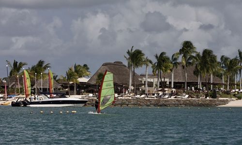 Sailboats in sea against sky