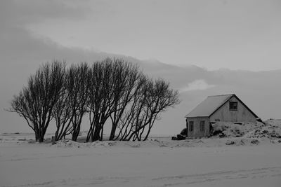 Built structure on snow covered field against sky black and white monochrome 