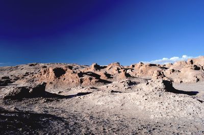 Low angle view of rocks against blue sky