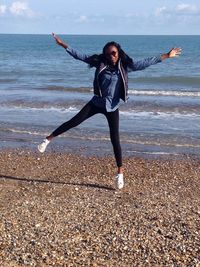 Full length of woman on beach against sky