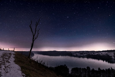 Scenic view of lake against sky at night