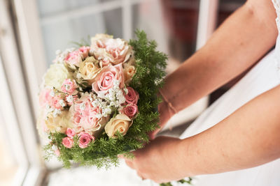 Midsection of woman holding rose bouquet