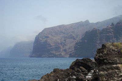 Rock formations by sea against sky