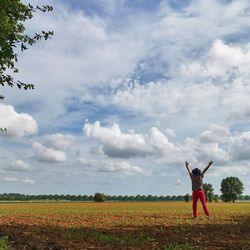 Woman standing on field against sky