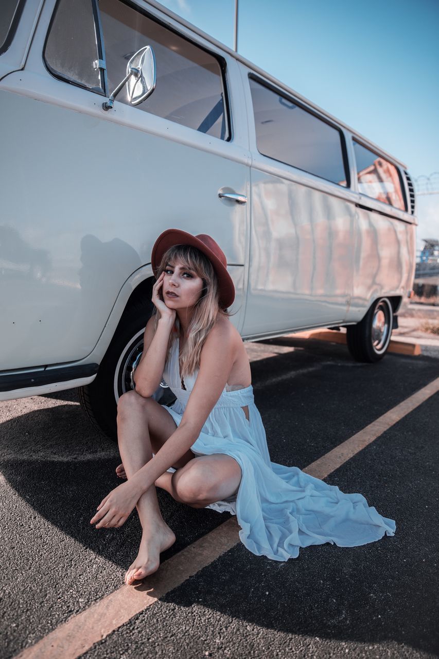 full length, one person, real people, lifestyles, transportation, mode of transportation, young women, young adult, leisure activity, portrait, women, looking at camera, land vehicle, beautiful woman, motor vehicle, casual clothing, sitting, day, fashion, hairstyle