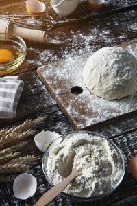 Rustic bread roll or french baguette, wheat and flour on black chalkboard. rural kitchen or bakery 