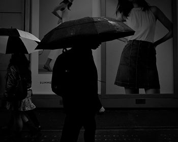 Silhouette of man with umbrella at night