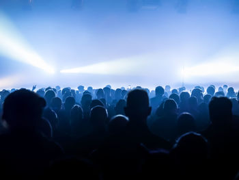 Rear view of silhouette crowd standing during music concert