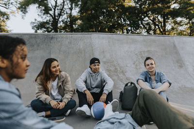 Teenagers sitting in skate park and talking