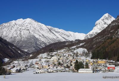 Houses against snowcapped mountains against clear sky