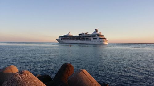 Cruise ship sailing in sea against clear sky during sunset