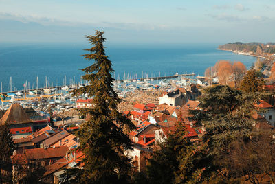 High angle view of town by sea against sky