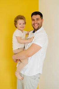 Happy father holds a four-year-old son in his arms. a cheerful family