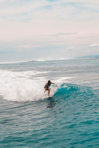 Man surfing on sea against sky