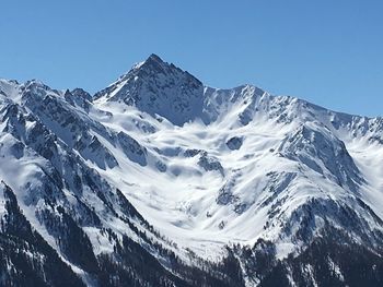 Scenic view of snowcapped mountains against clear blue sky