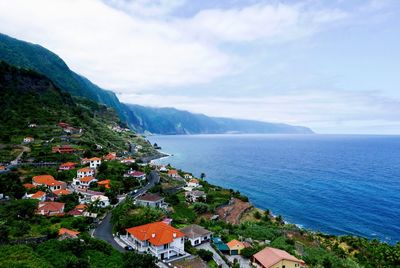 High angle view of houses by sea against sky