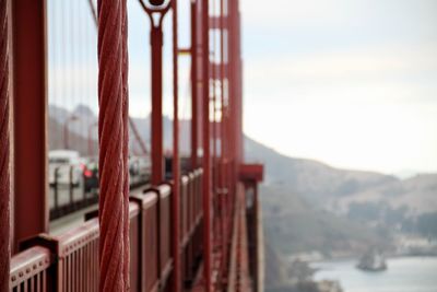 Close-up of railing by bay against sky
