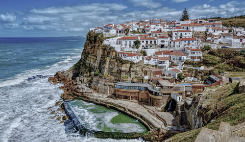 Panoramic view of sea and buildings against sky