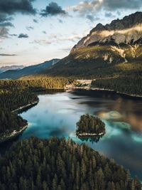 Scenic view of lake by mountains against sky