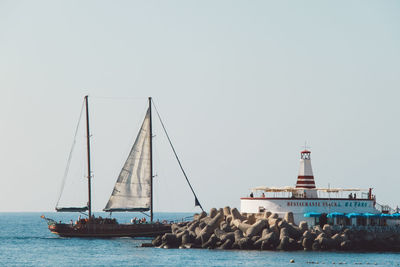 Sailboat sailing in sea against clear sky
