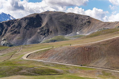 Scenic view of road by mountains against sky