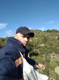 Young man wearing hat against sky