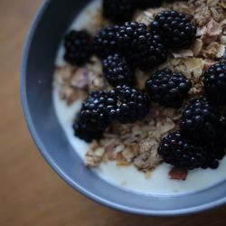 Close-up of blackberries on granola in bowl at table