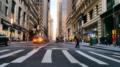 People walking on road along buildings