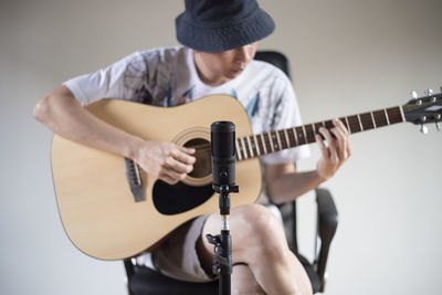 Midsection of man playing guitar