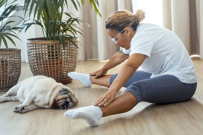 Side view of young woman with dog at home