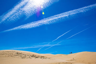 Scenic view of desert against blue sky