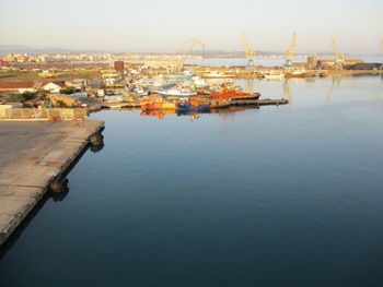 High angle view of commercial dock by sea against city