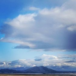 Scenic view of mountains against cloudy sky