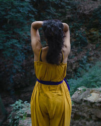 Rear view of woman standing in forest