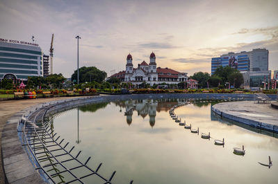 Reflection of buildings in city at sunset