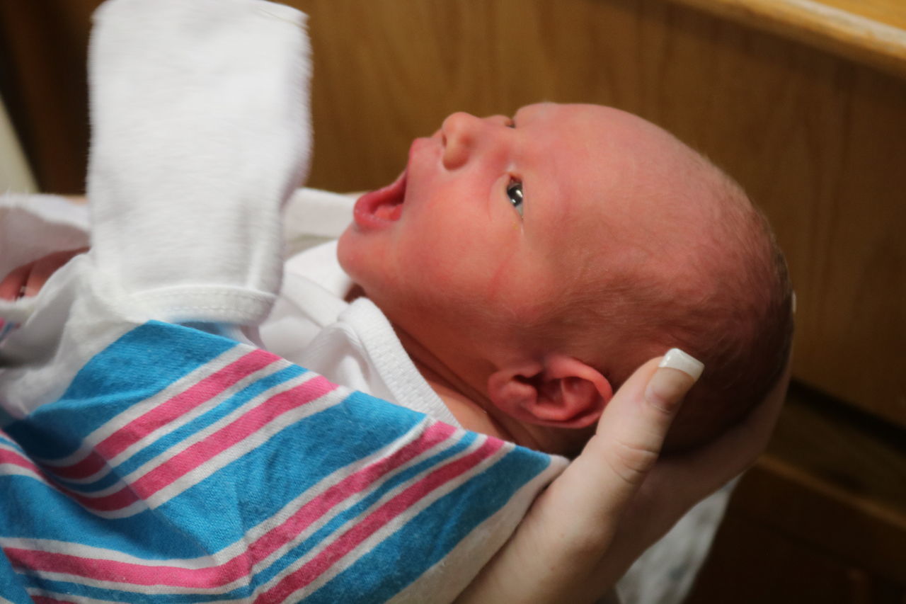 CLOSE-UP OF BABY GIRL WITH HAND