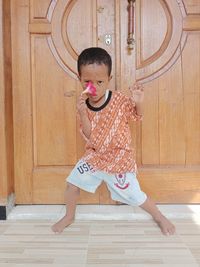 Full length of cute girl standing on wooden floor