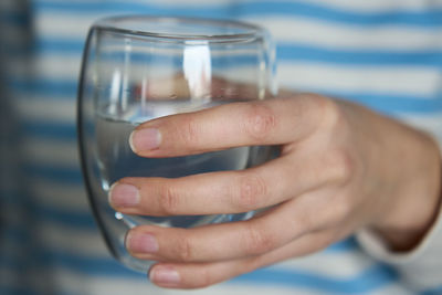 Woman drinks water, close-up shot of man holding glass of fresh water