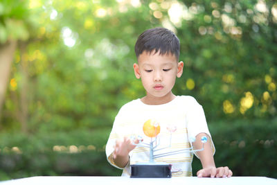 Boy playing with toy while standing outdoors